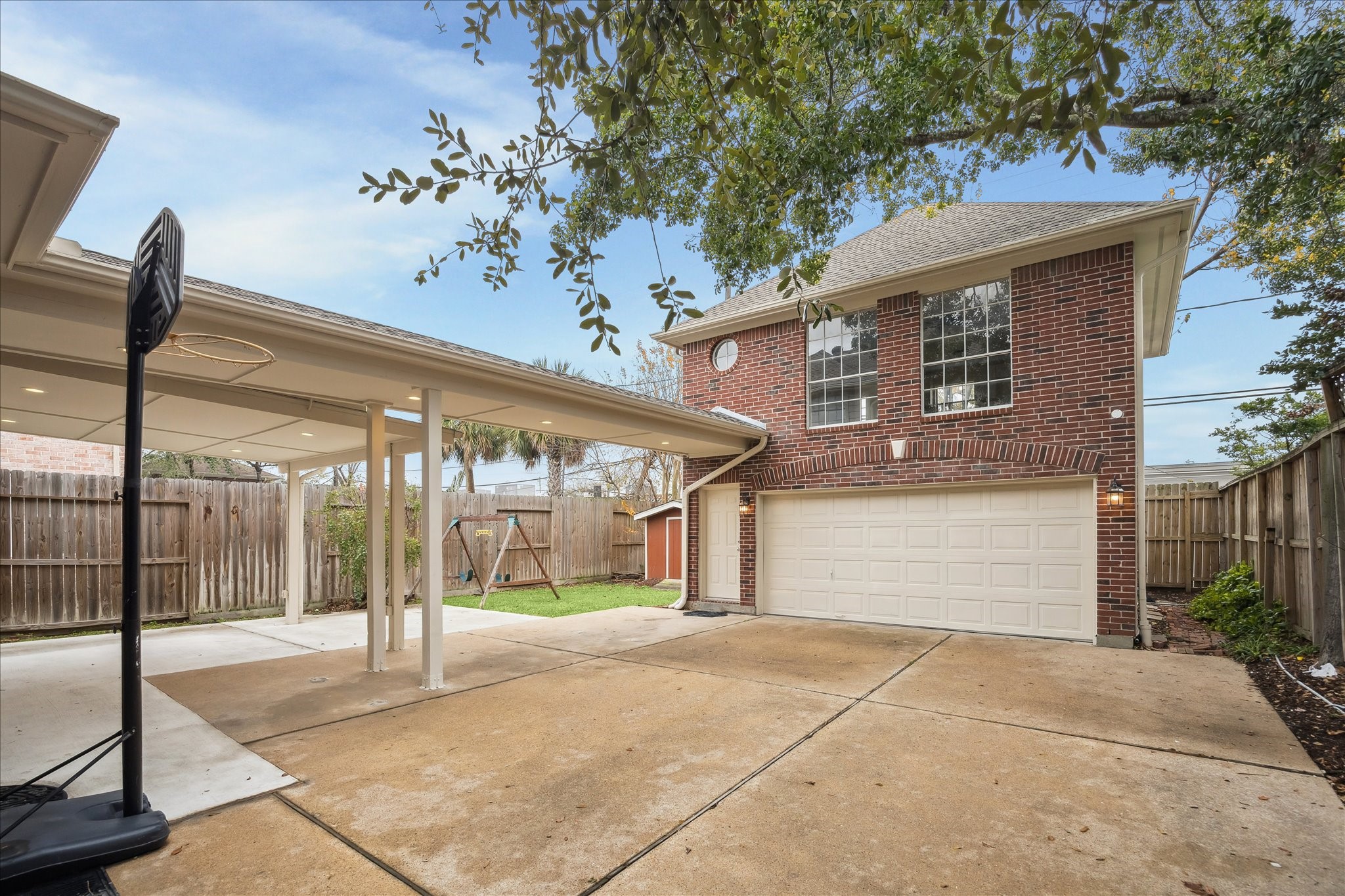 5107 Locust Street Bellaire, TX 77401 - Photo 2 of 45 Detached two-car garage with a private upstairs apartment, plus a covered patio & covered walkway leading from the garage to the back door, offering flexible space for guests, a home office, or additional living needs.