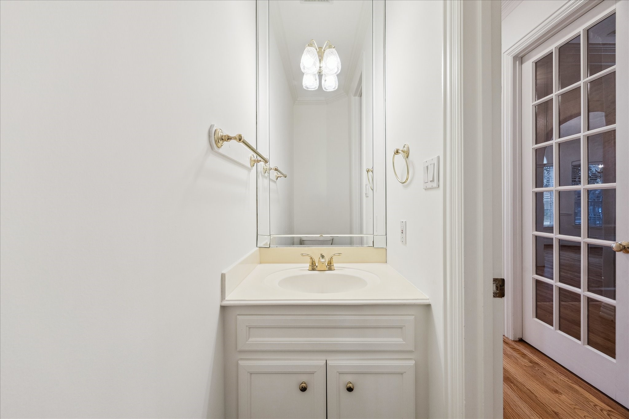 5107 Locust Street Bellaire, TX 77401 - Photo 21 of 45 Powder bath featuring a single vanity with framed mirror, updated lighting, & classic finishes—conveniently located near the main living areas.