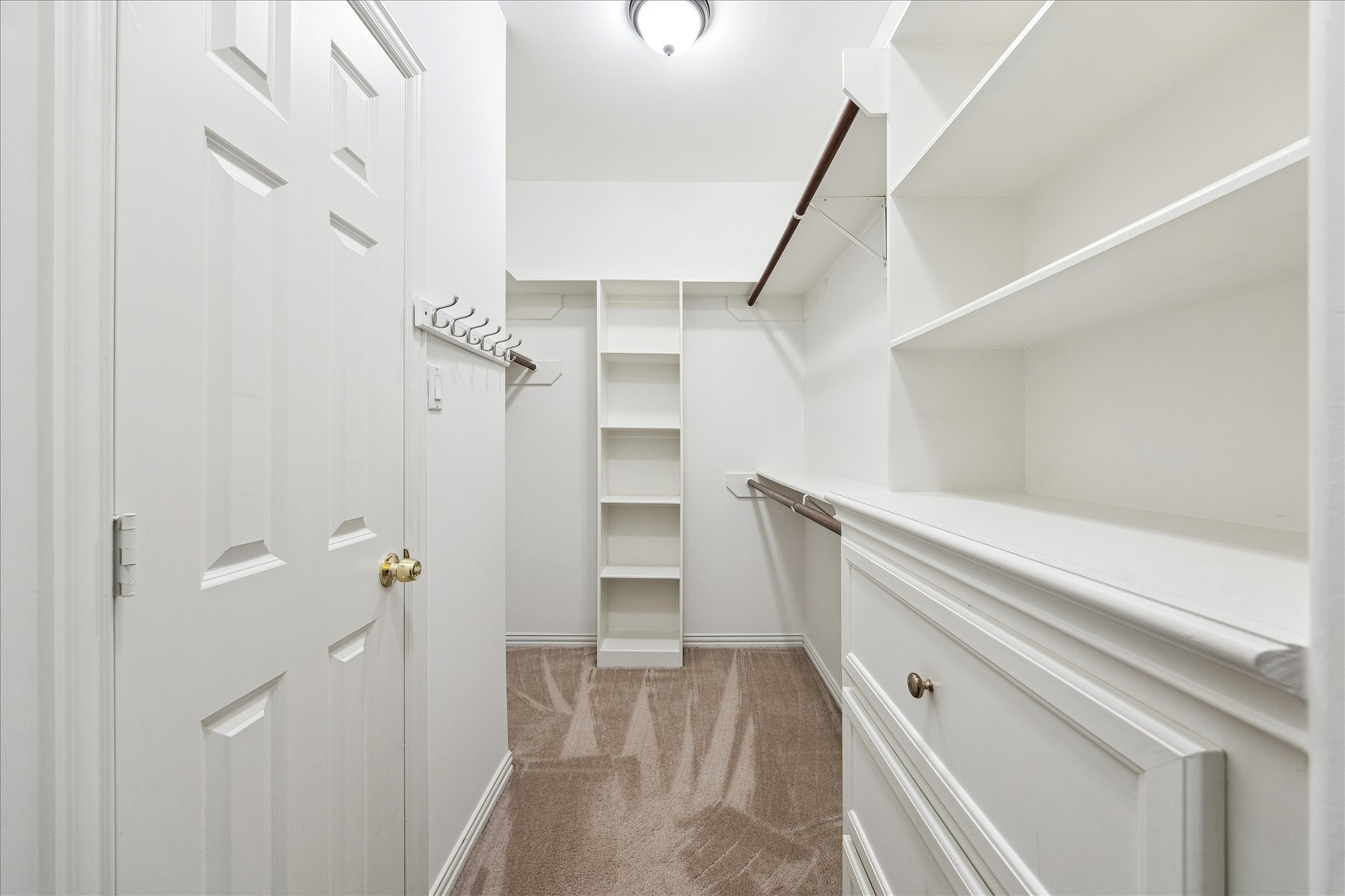 5107 Locust Street Bellaire, TX 77401 - Photo 30 of 45 Spacious walk-in closet with custom built-in shelving, hanging rods, and dedicated storage compartments, offering an organized and functional extension of the primary suite.