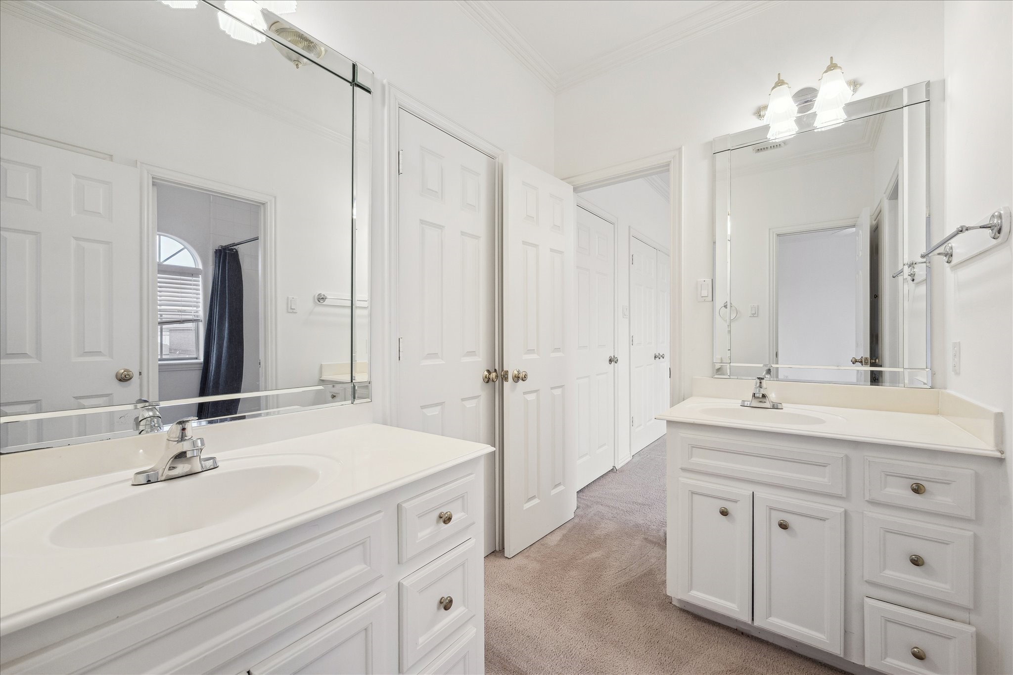 5107 Locust Street Bellaire, TX 77401 - Photo 34 of 45 Light & bright bath conveniently located between two secondary bedrooms, featuring dual vanities, expansive mirrors, classic cabinetry, & a functional layout designed for everyday ease and privacy.