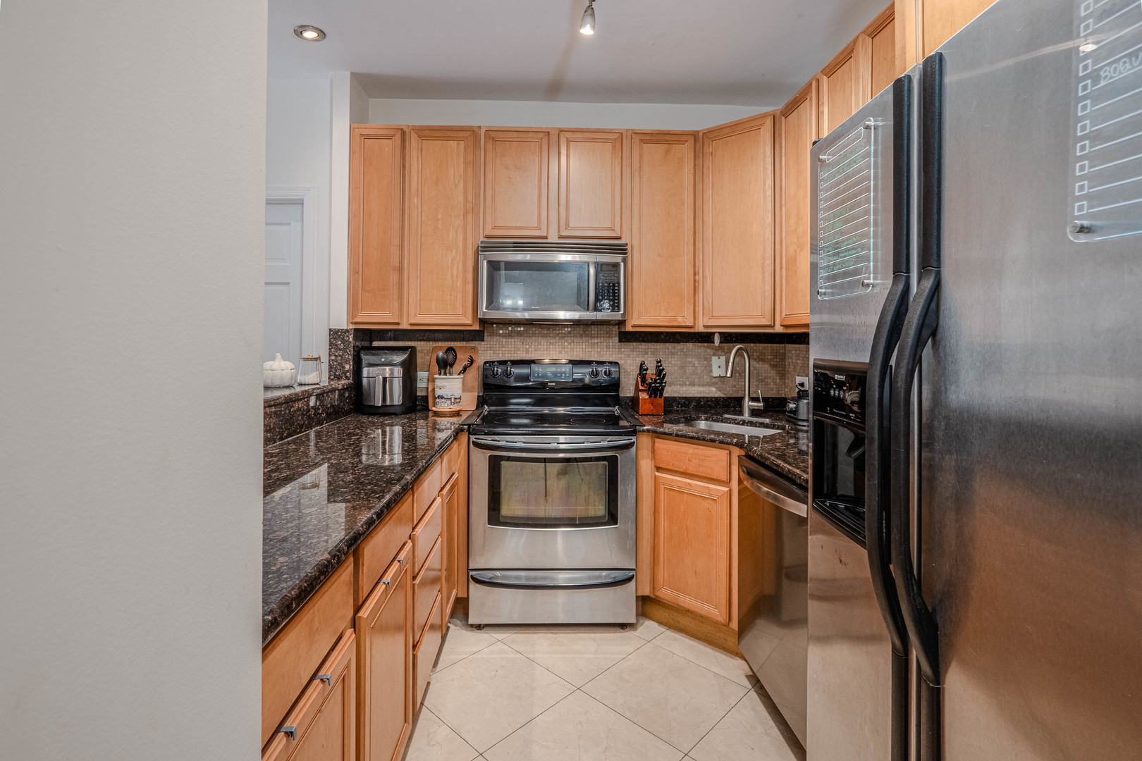 525 West Hawthorne Place, Unit 101 Chicago, IL 60657 - Photo 11 of 28 a kitchen with granite countertop a refrigerator stove top oven and sink