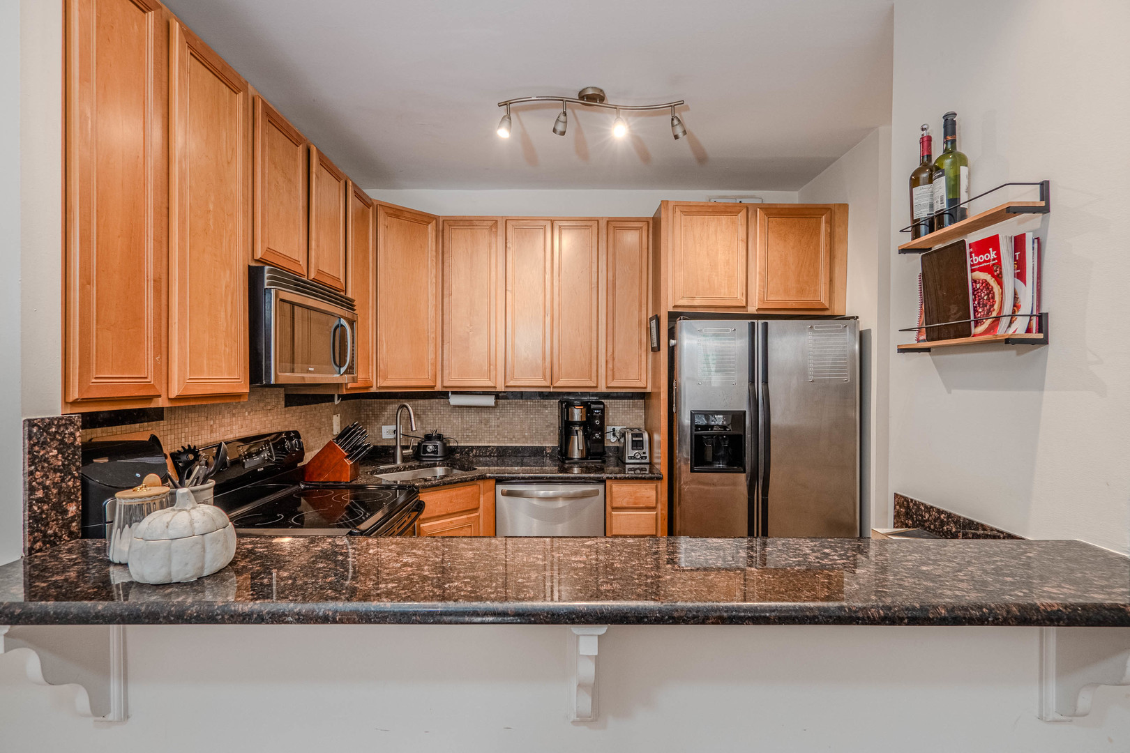 525 West Hawthorne Place, Unit 101 Chicago, IL 60657 - Photo 12 of 28 a kitchen with stainless steel appliances granite countertop a refrigerator a stove and a sink with wooden floor