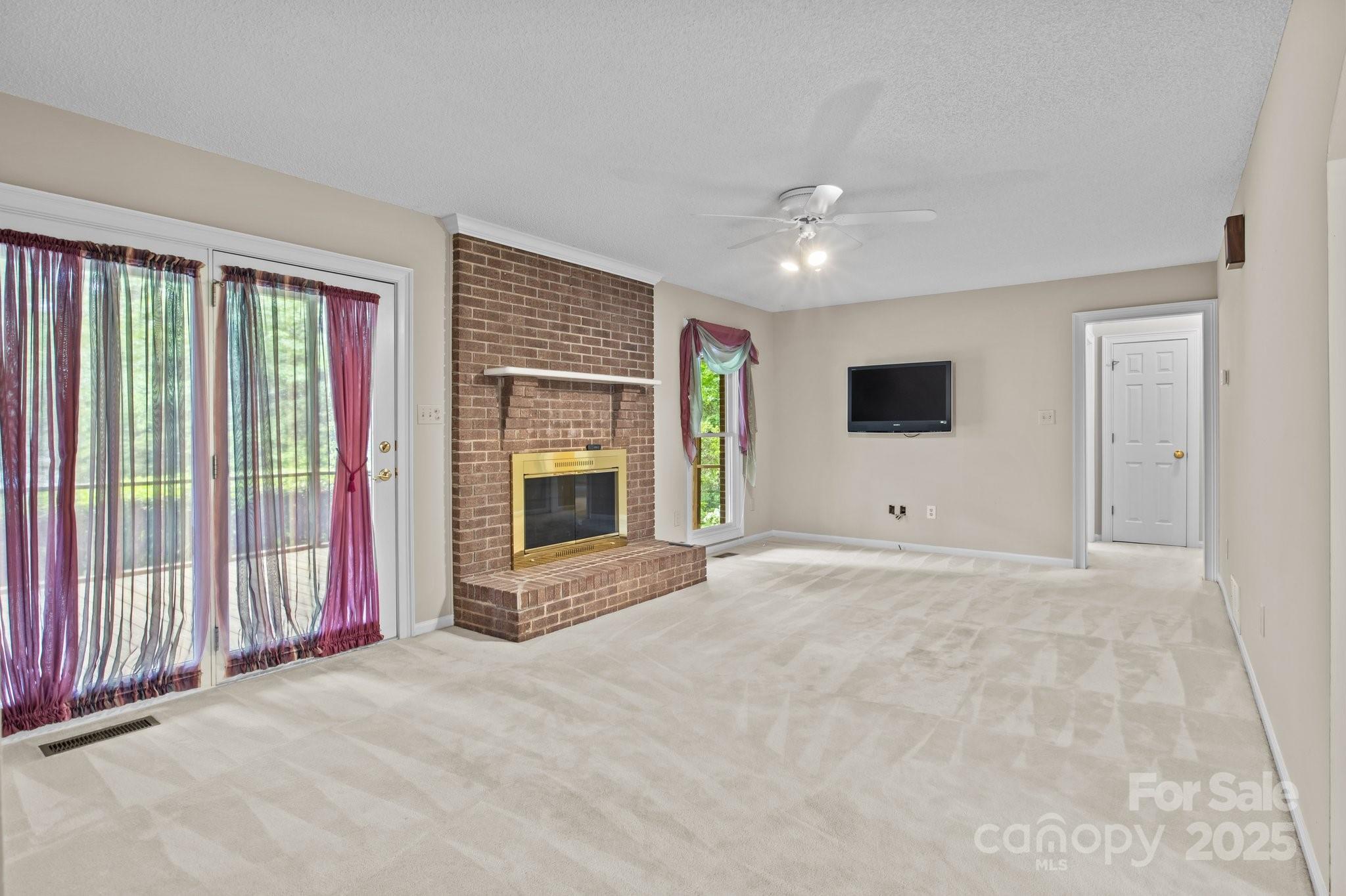 8368 Fairfield Forest Road Denver, NC 28037 - Photo 14 of 48 a view of an empty room with a fireplace and a window
