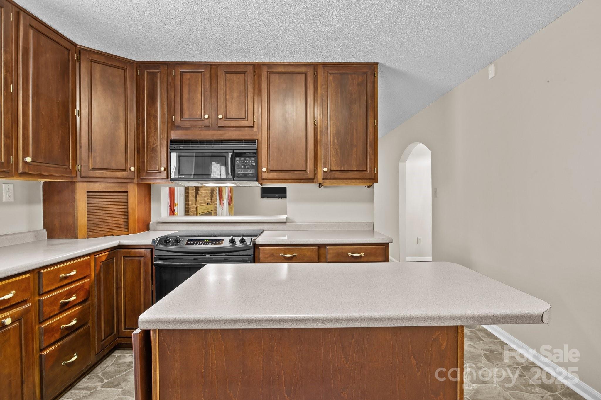 8368 Fairfield Forest Road Denver, NC 28037 - Photo 17 of 48 a kitchen with kitchen island granite countertop wooden cabinets and sink
