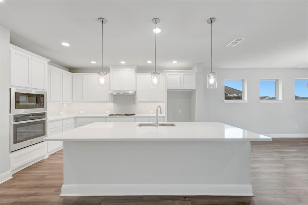 8916 Chestnut Lane Justin, TX 76247 - Photo 12 of 17 a kitchen with kitchen island a stove and a wooden floor