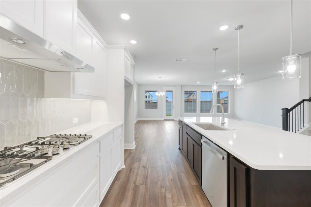 8916 Chestnut Lane Justin, TX 76247 - Photo 13 of 17 a kitchen with granite countertop a sink stove and wooden floor