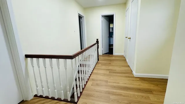 a view of a hallway with wooden floor and staircase