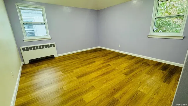 a view of a room with wooden floor and windows