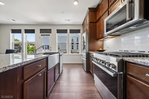 a kitchen with stainless steel appliances granite countertop a stove and a sink