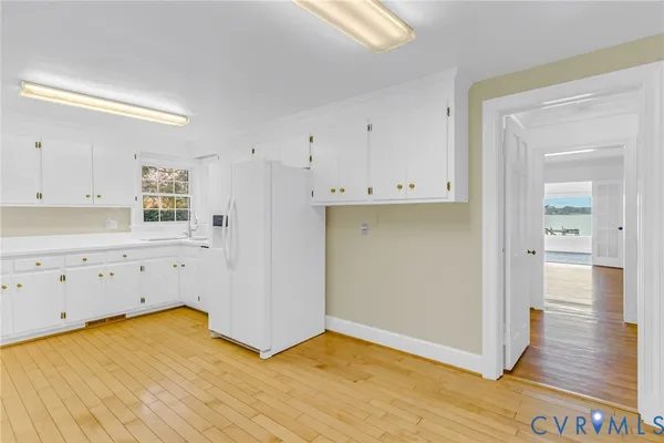 a kitchen with wooden floors and white appliances