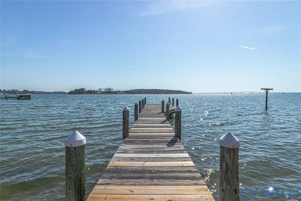 a view of a white house with large windows and a small yard