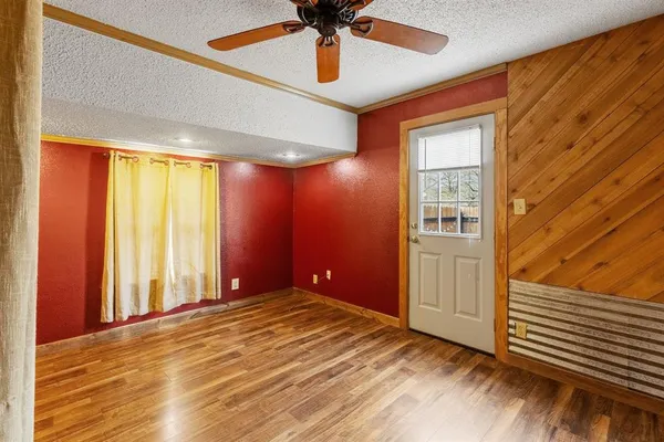 a view of an empty room with window and wooden floor