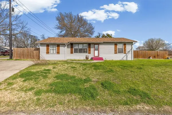 a view of a house with a big yard and large trees