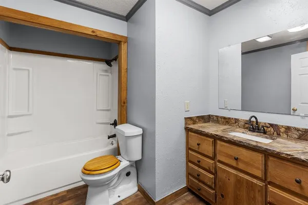 a bathroom with a granite countertop toilet sink and mirror