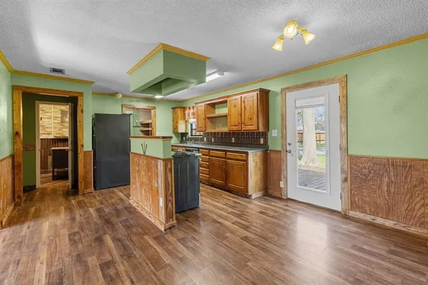 a kitchen with stainless steel appliances granite countertop a refrigerator a stove top oven a sink and dishwasher with wooden floor