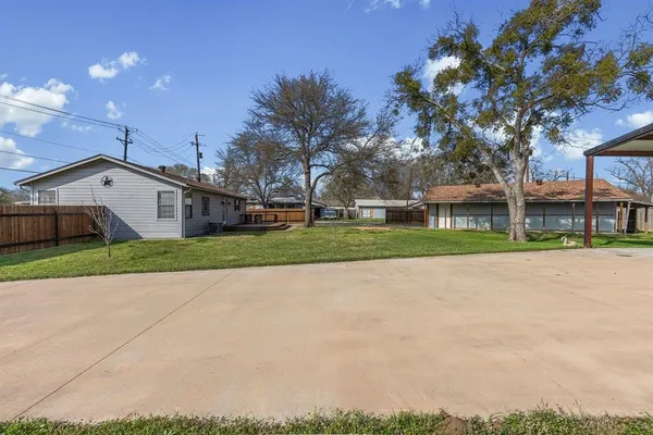 a view of a white house with a yard and large tree