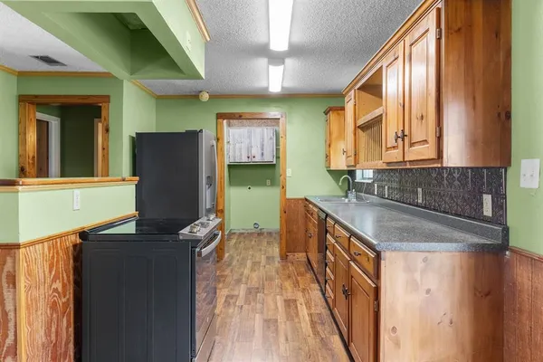a kitchen with granite countertop a sink a counter top space and cabinets
