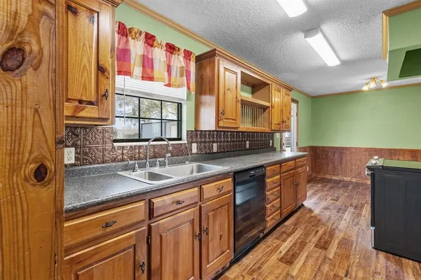 a kitchen with stainless steel appliances granite countertop a sink and dishwasher a stove with wooden floor