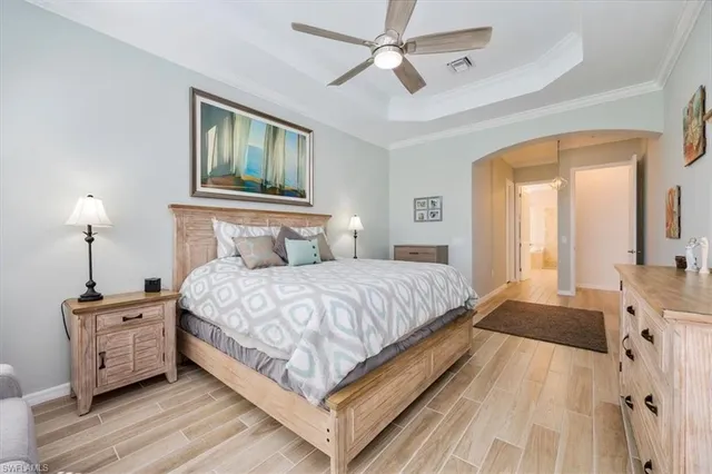 a bedroom with a large bed and a chandelier