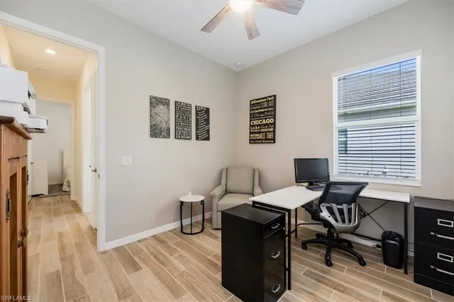 a view of a workspace with furniture and a window