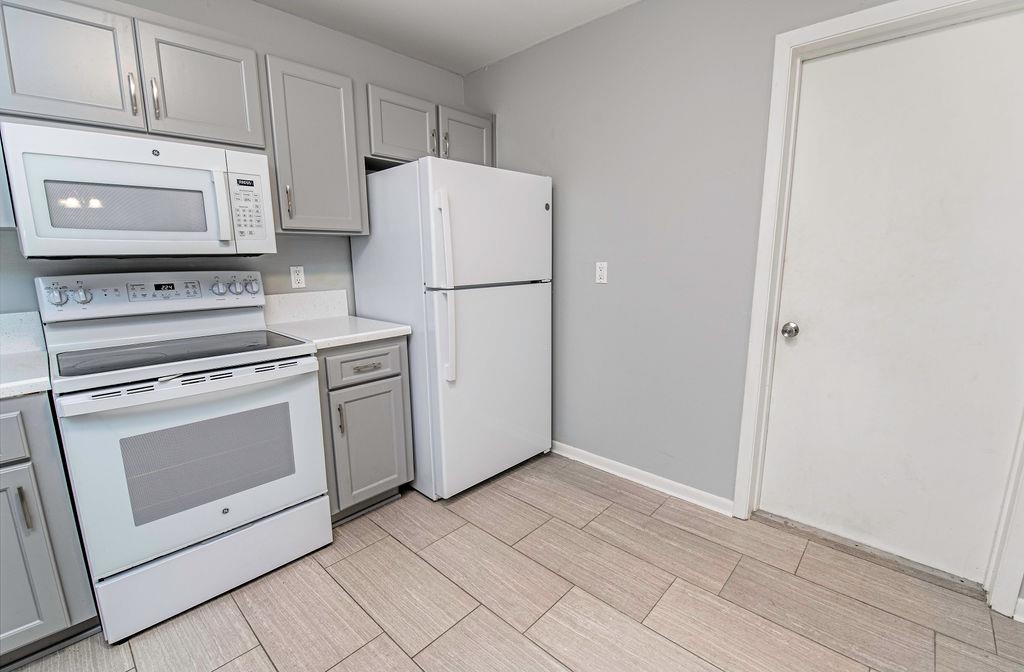 1061 Mindello Avenue St. Augustine, FL 32086 - Photo 11 of 26 a kitchen with white cabinets and white appliances