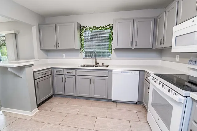 a kitchen with a stove sink and cabinets