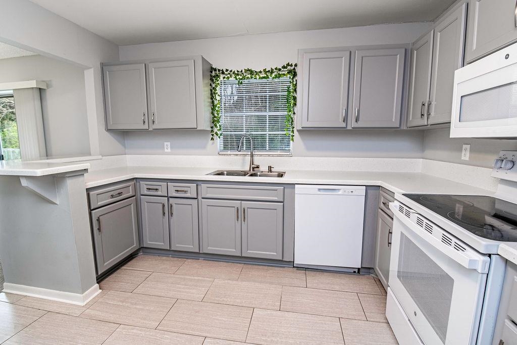 1061 Mindello Avenue St. Augustine, FL 32086 - Photo 3 of 26 a kitchen with a stove sink and cabinets