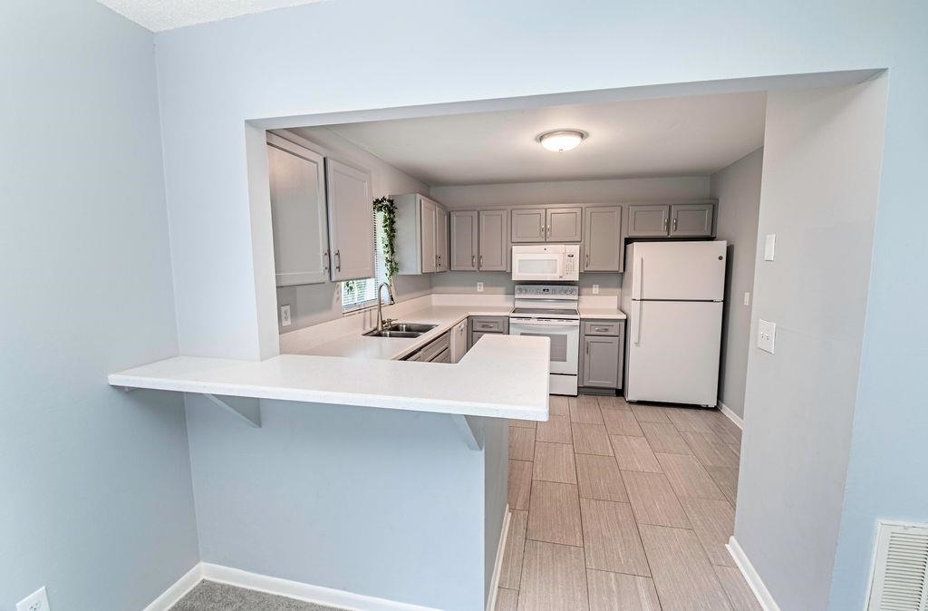 1061 Mindello Avenue St. Augustine, FL 32086 - Photo 10 of 26 a kitchen with a sink a refrigerator and white cabinets