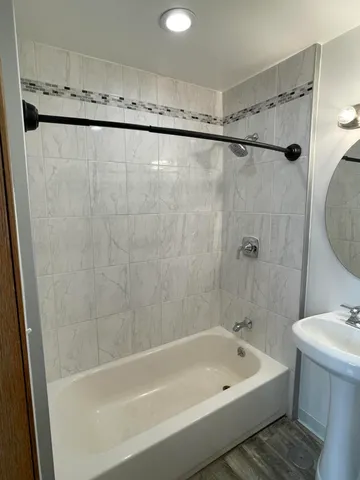 a bathroom with a shower a bath tub and a shower