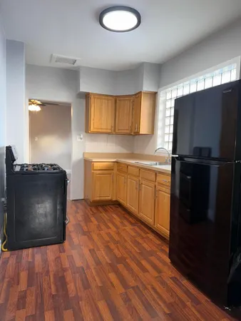 a kitchen with wooden cabinets and black appliances