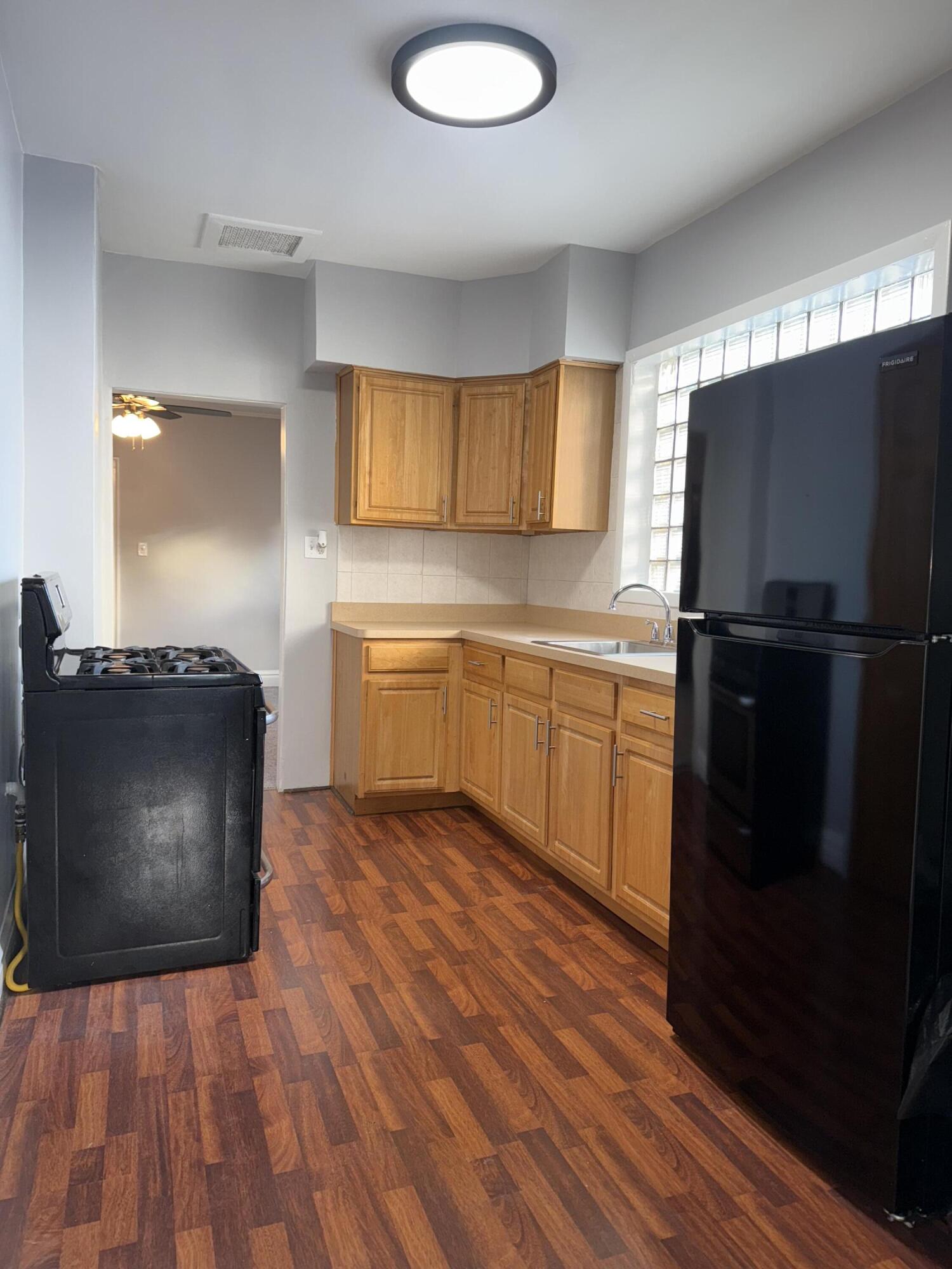 1820 Davis Avenue Whiting, IN 46394 - Photo 19 of 27 a kitchen with wooden cabinets and black appliances