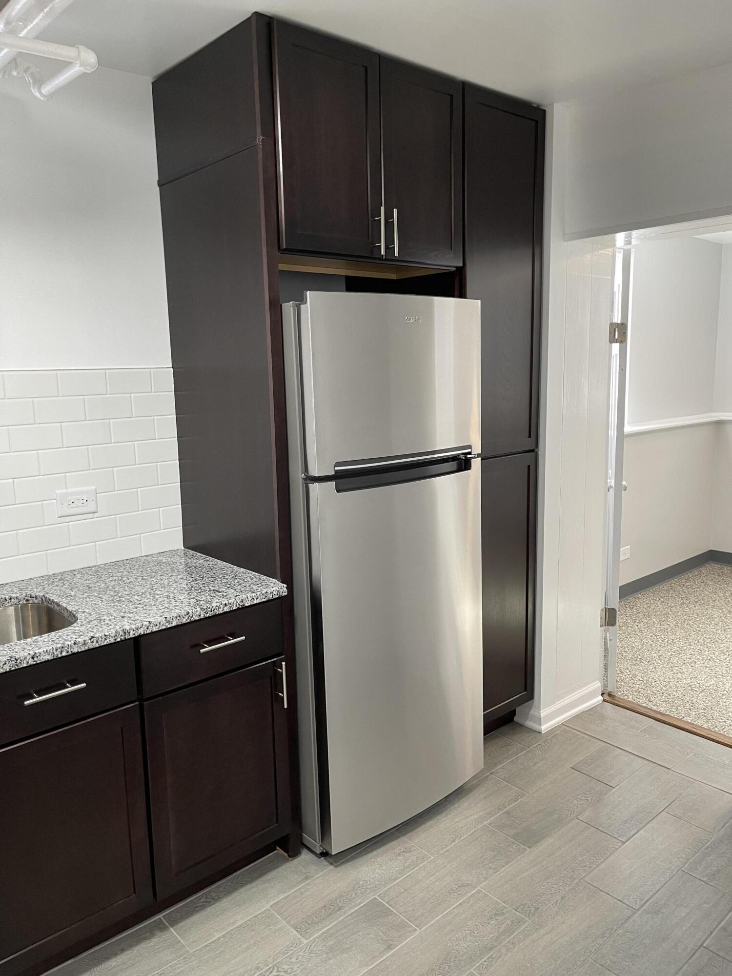 1820 Davis Avenue Whiting, IN 46394 - Photo 4 of 27 a view of a refrigerator in kitchen and an empty room with wooden floor