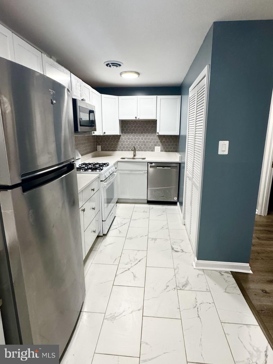 218 Locust Street Southeast, Unit 143 Vienna, VA 22180 - Photo 5 of 14 a kitchen with stainless steel appliances granite countertop a refrigerator and a stove top oven