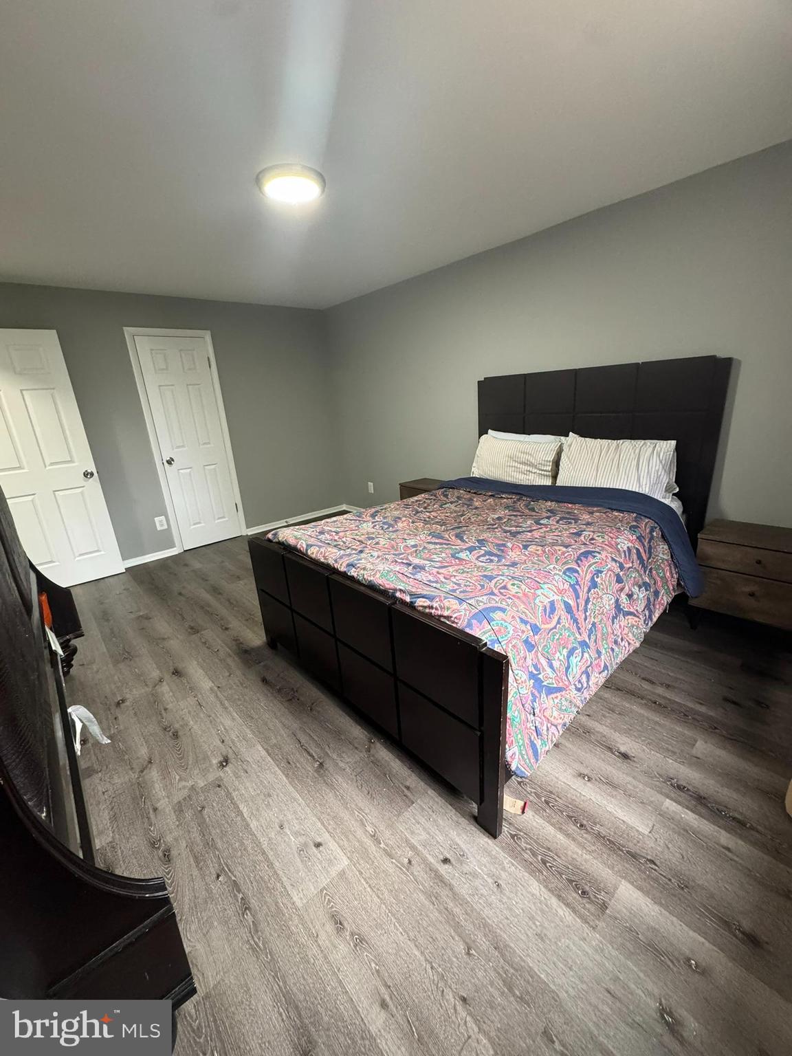 218 Locust Street Southeast, Unit 143 Vienna, VA 22180 - Photo 8 of 14 a bedroom with a bed and wooden floor
