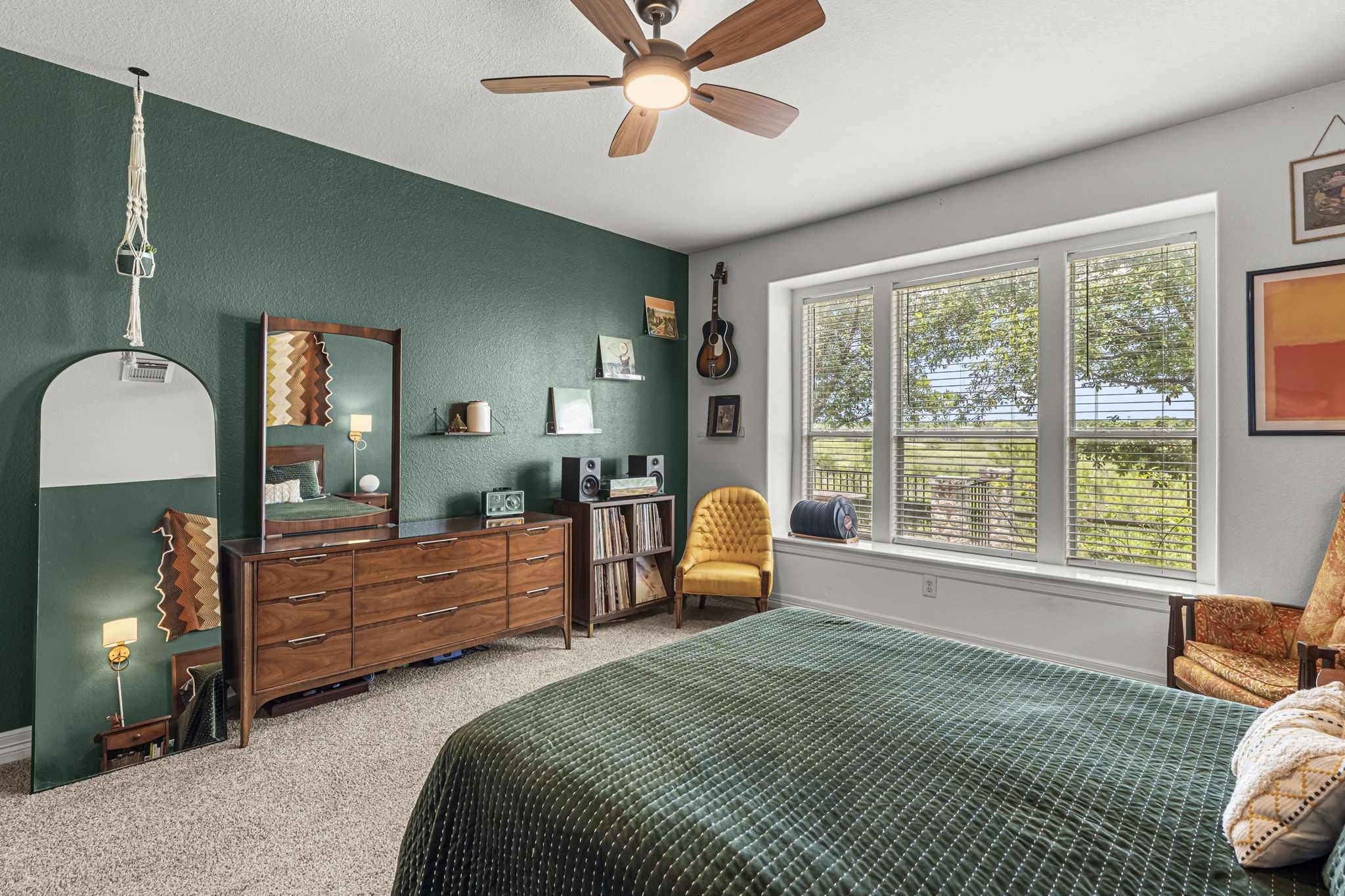 454 Fall Circle Kyle, TX 78640 - Photo 19 of 39 A vibrant bedroom provides a serene retreat, complete with expansive windows offering verdant outdoor views.