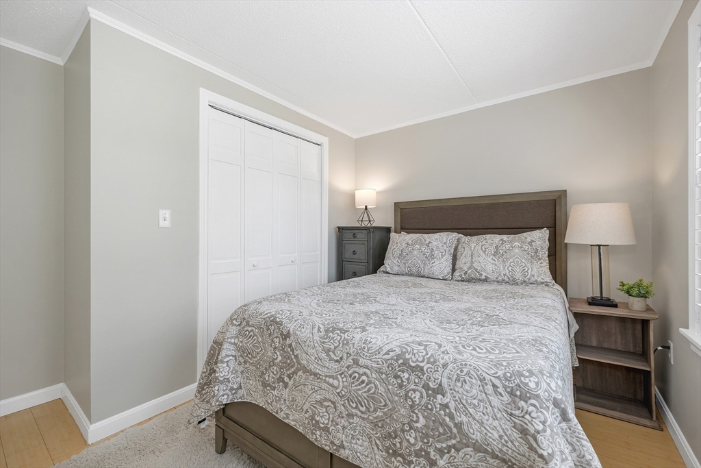 64 Esker Road, Unit 2 Hampton, NH 03842 - Photo 13 of 35 a bed room with a bed and a night stand