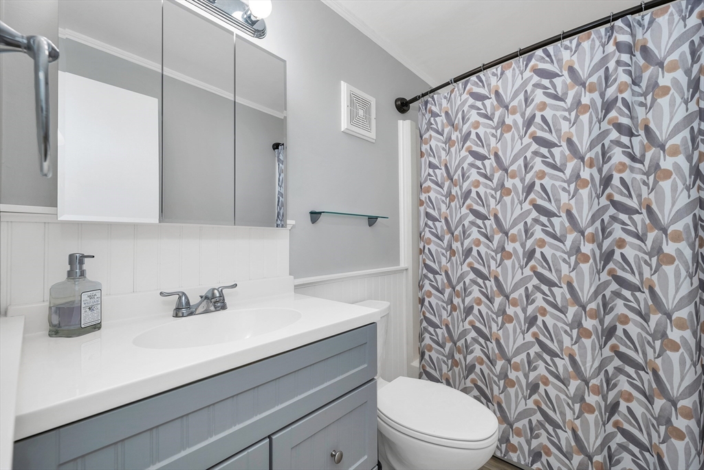 64 Esker Road, Unit 2 Hampton, NH 03842 - Photo 15 of 35 a bathroom with a sink a toilet and shower curtain