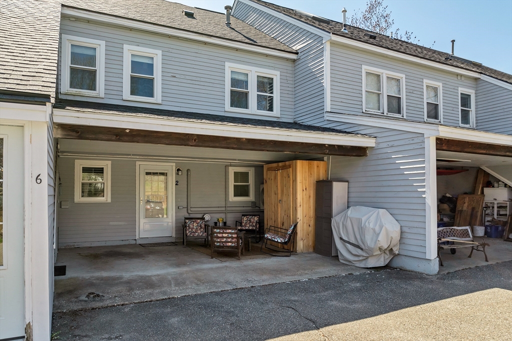 64 Esker Road, Unit 2 Hampton, NH 03842 - Photo 24 of 35 a view of a house with a barbeque and chair and a barbeque