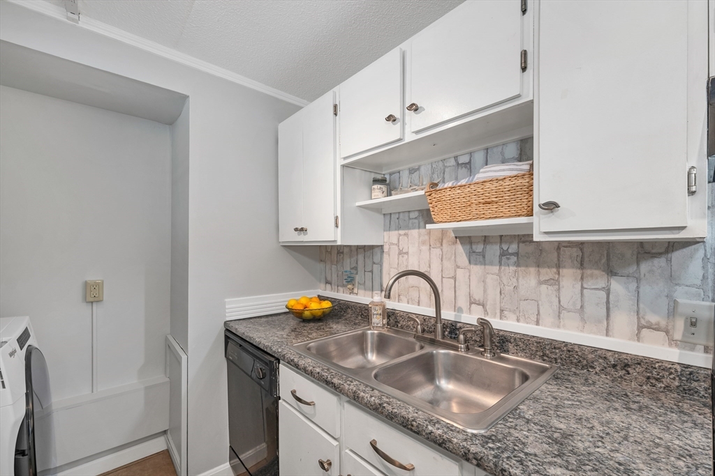 64 Esker Road, Unit 2 Hampton, NH 03842 - Photo 8 of 35 a kitchen with granite countertop a sink a stove and cabinets