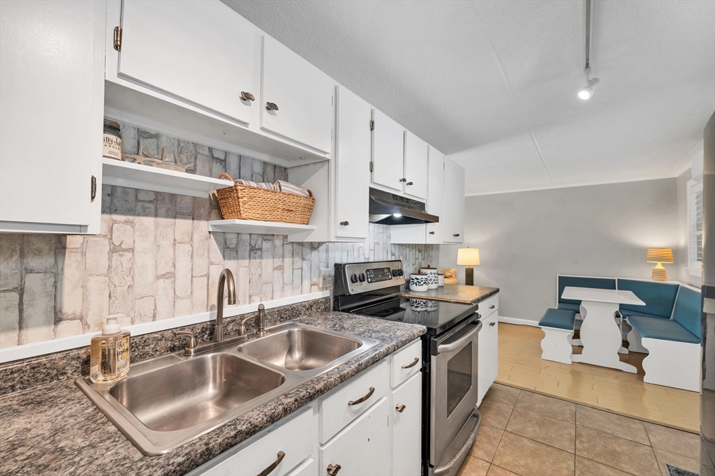 64 Esker Road, Unit 2 Hampton, NH 03842 - Photo 10 of 35 a kitchen with stainless steel appliances granite countertop a sink stove and cabinets
