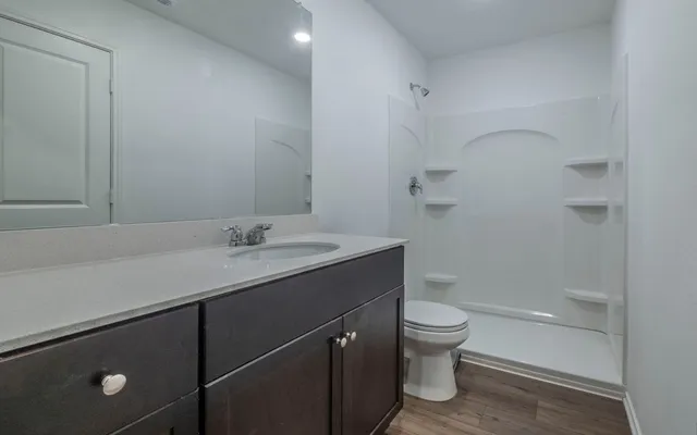 a bathroom with a granite countertop sink toilet and shower