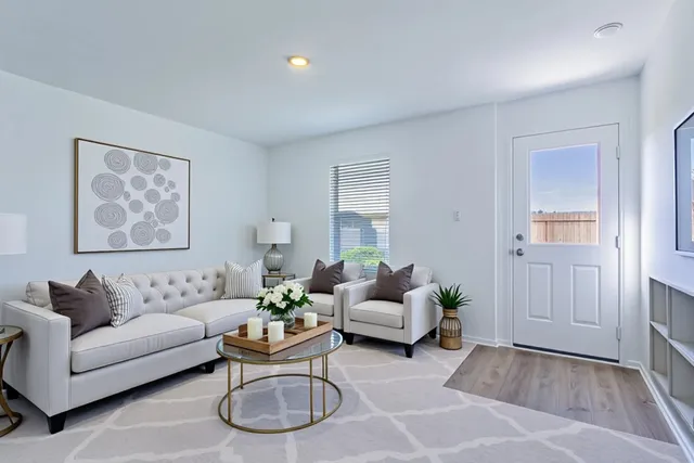 a living room with furniture and wooden floor