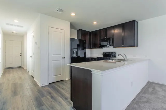 a kitchen with kitchen island white cabinets and refrigerator