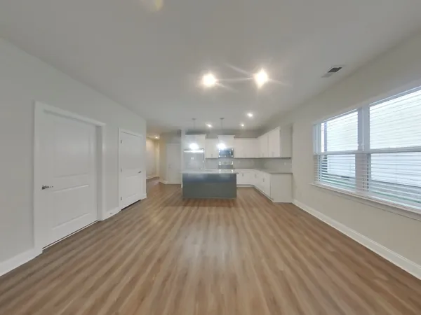 a view of a kitchen with a sink and wooden floor