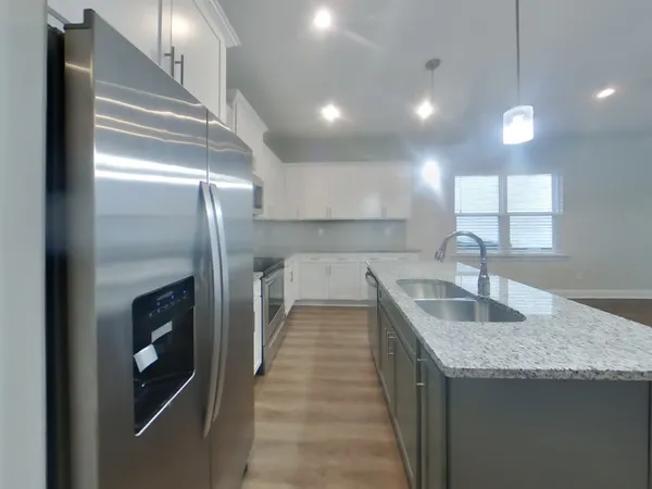 a kitchen with stainless steel appliances granite countertop a sink and a refrigerator