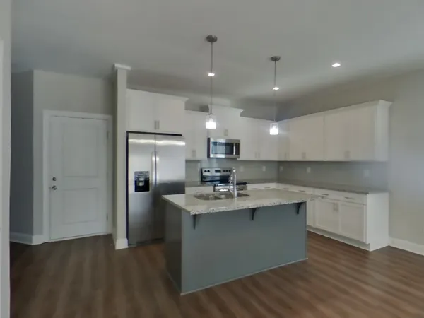 a kitchen with kitchen island a sink stainless steel appliances and cabinets