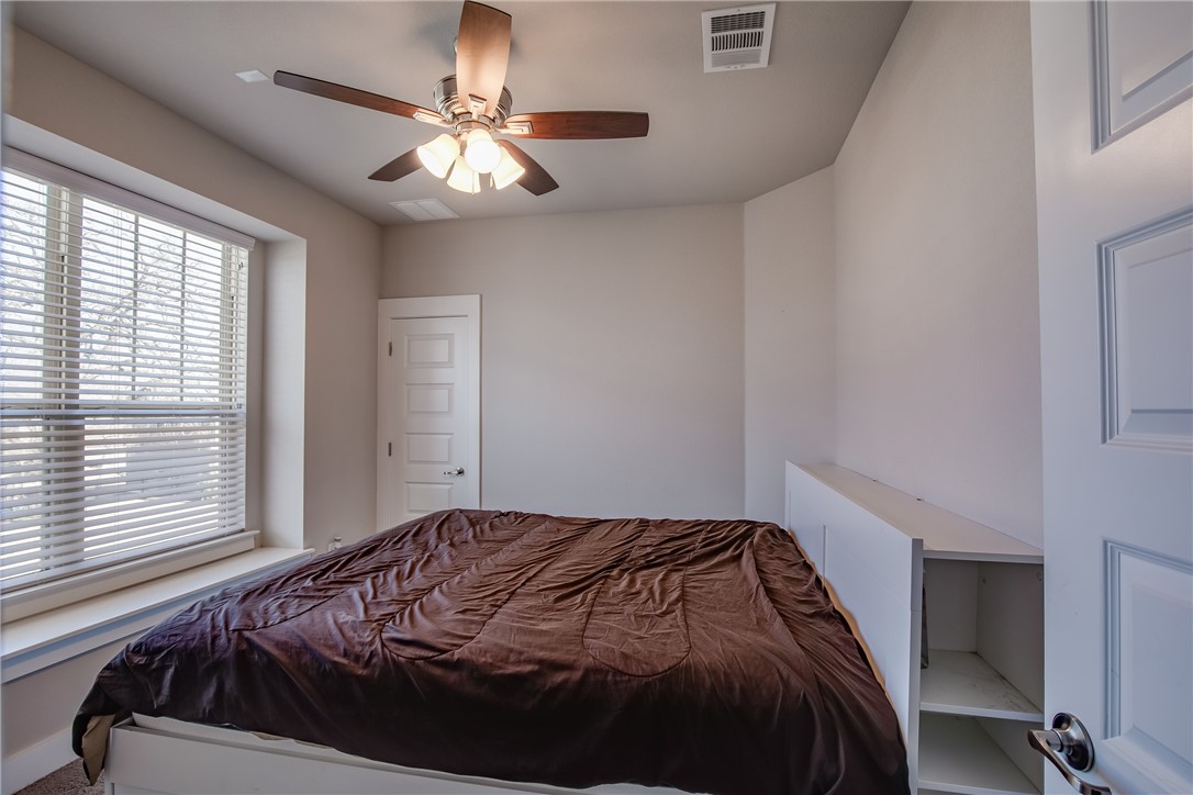 9707 McKnight Loop Austin, TX 78717 - Photo 12 of 17 a bedroom with a bed and a chandelier