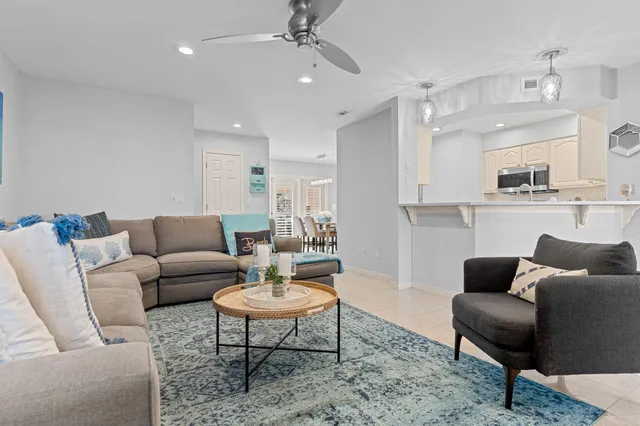 a living room with furniture and a view of kitchen