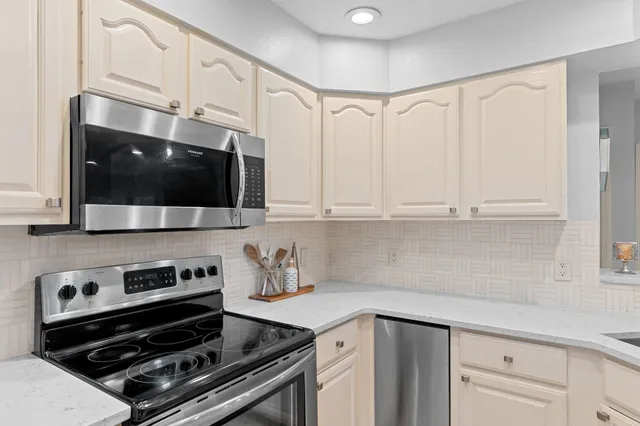 a kitchen with stainless steel appliances a sink a stove and cabinets