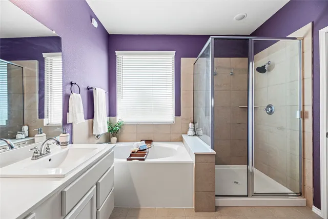 a bathroom with a tub sink and mirror